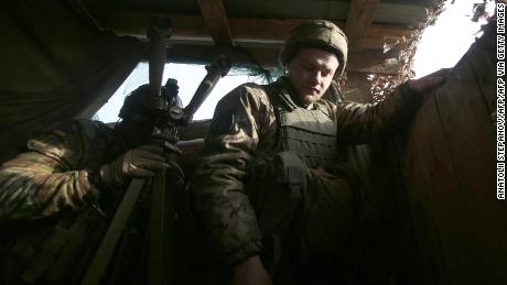 Um soldado ucraniano olha através de binóculos na linha de frente com separatistas apoiados pela Rússia, perto de Novologansk, na região de Donetsk, em 17 de fevereiro de 2022. 
